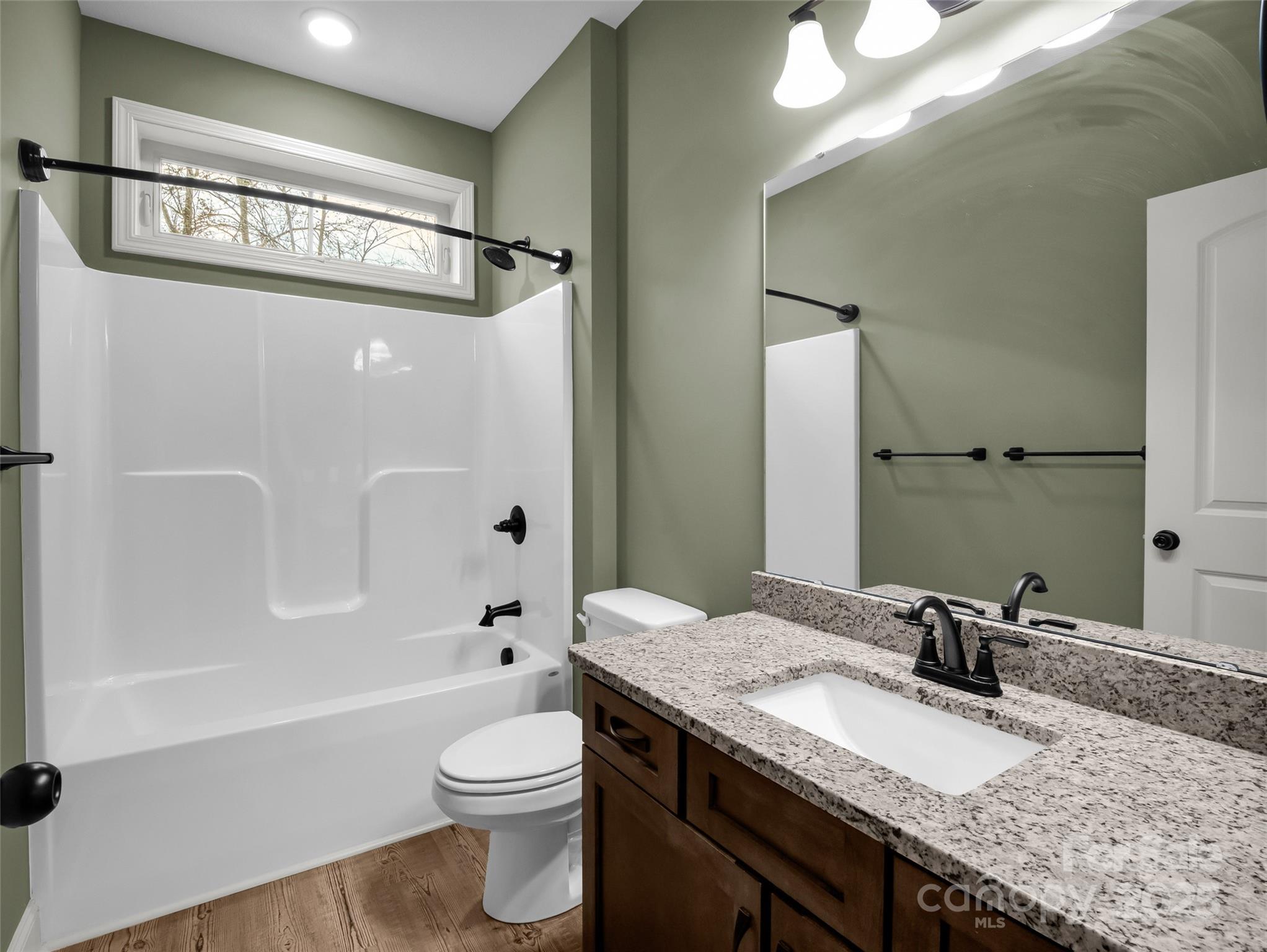 140 Cv Crst Drive Rutherfordton, NC 28139 - Photo 28 of 48 a bathroom with a granite countertop sink a toilet a mirror a bathtub and shower