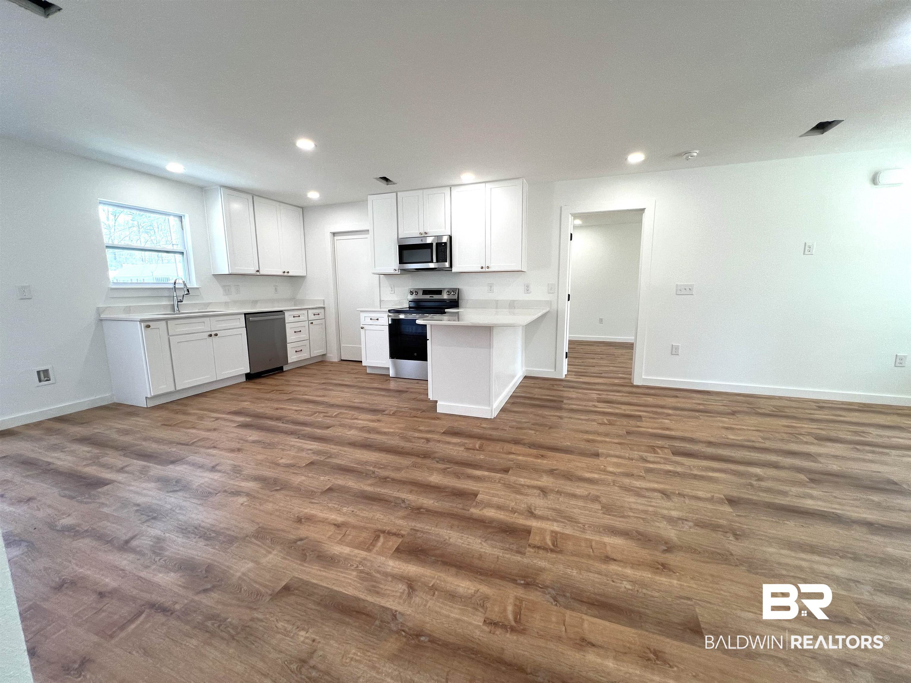 102 Earl Street Brewton, AL 36426 - Photo 27 of 27 Kitchen with white cabinets, open floor plan, stainless steel appliances, a sink, and recessed lighting