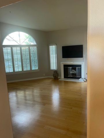an empty room with windows fireplace and wooden floor