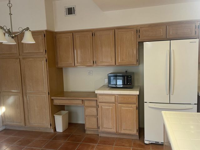 a kitchen with a sink a refrigerator and cabinets