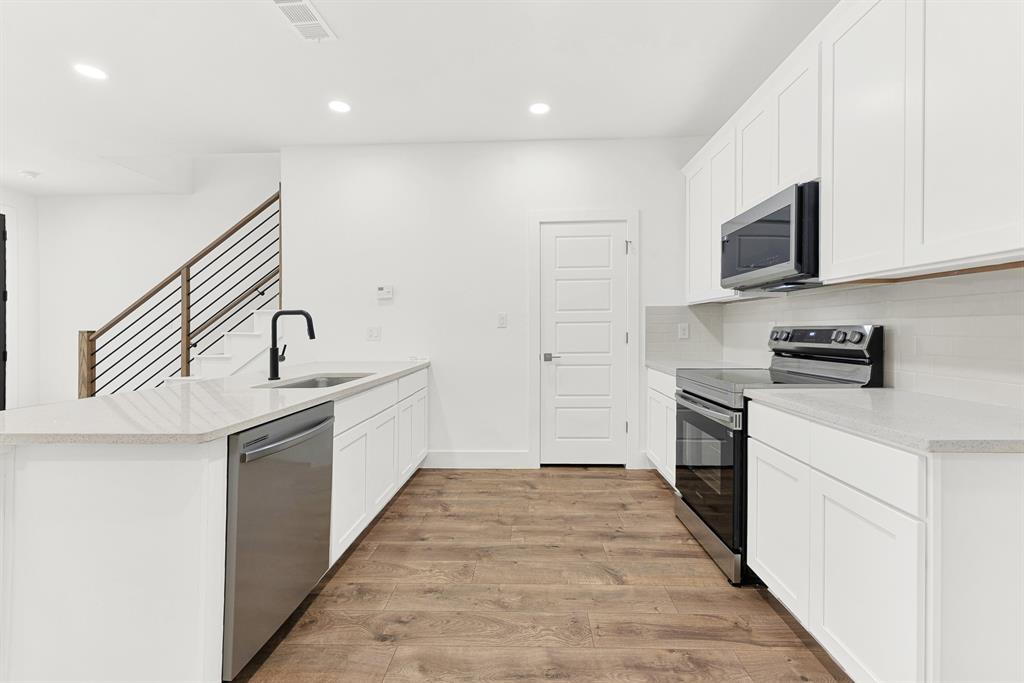 9471 Timberleaf Drive Dallas, TX 75243 - Photo 8 of 39 Contemporary kitchen featuring white cabinetry, light-toned countertops, and wood-finish flooring