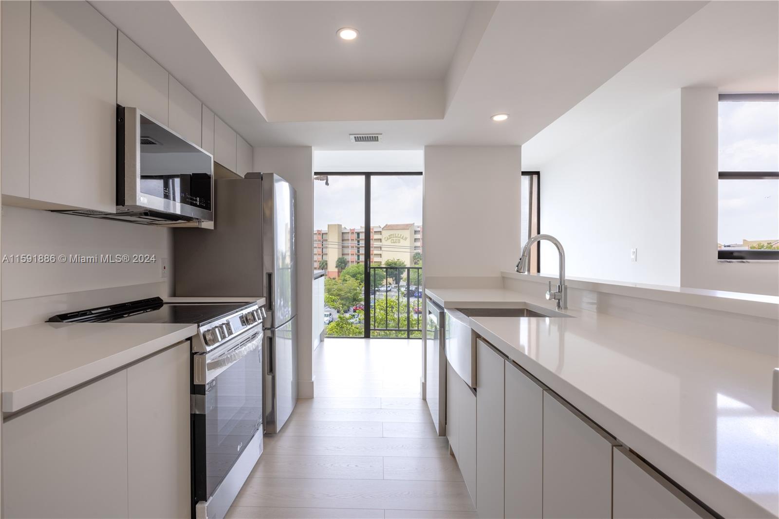 9400 West Flagler Street, Unit 413 Miami, FL 33174 - Photo 4 of 17 a kitchen with stainless steel appliances granite countertop a sink a stove and a refrigerator