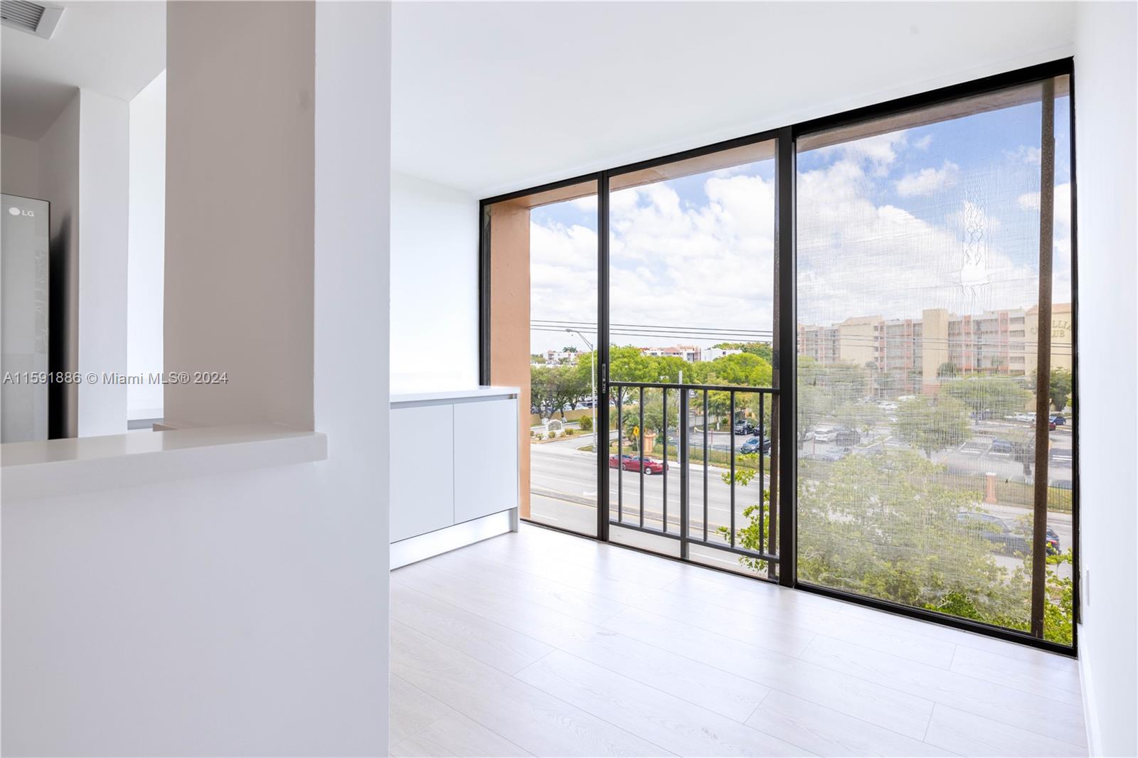 9400 West Flagler Street, Unit 413 Miami, FL 33174 - Photo 6 of 17 a view of an empty room with wooden floor and doors