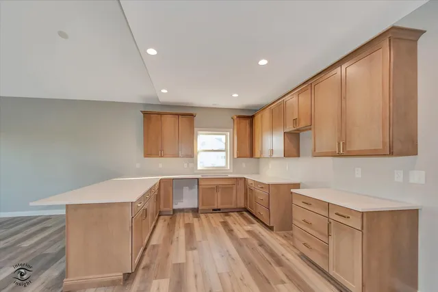 a view of a kitchen with a sink and dishwasher cabinet with wooden floor