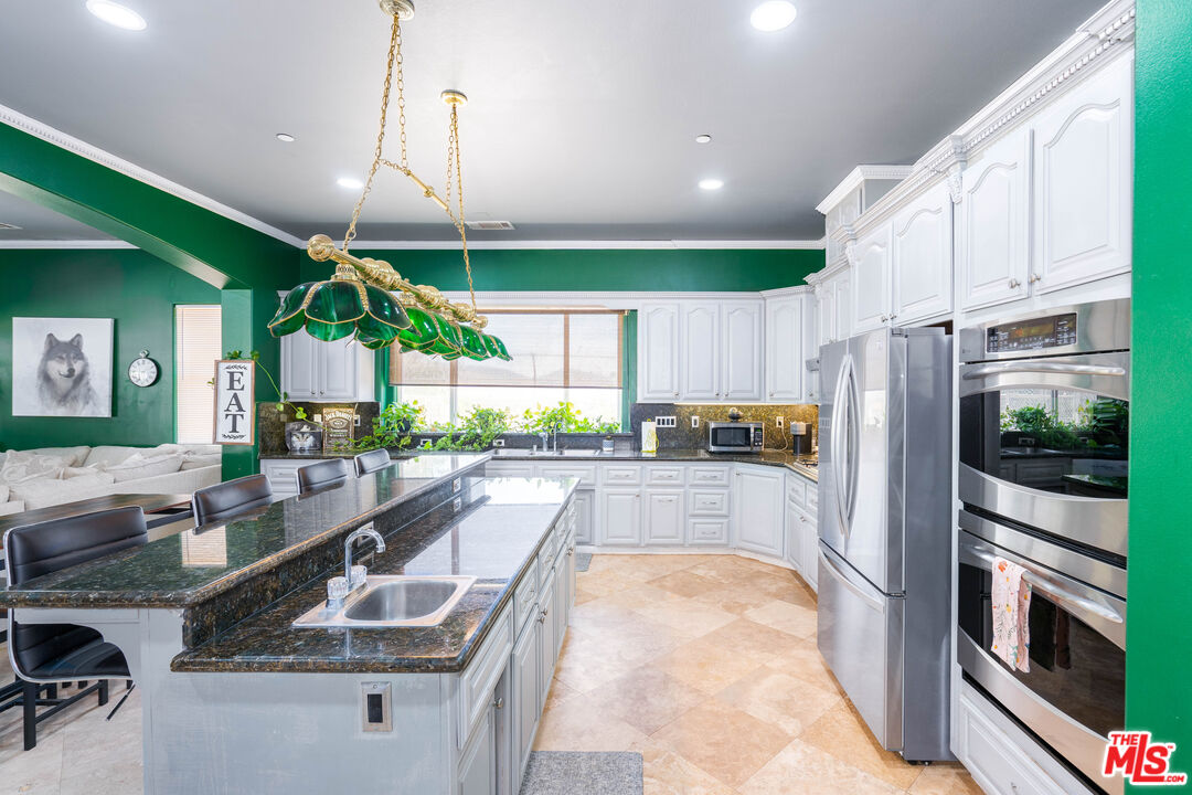 34545 Juniper Valley Road Acton, CA 93510 - Photo 8 of 34 a kitchen with kitchen island granite countertop a sink a counter top stainless steel appliances and cabinets