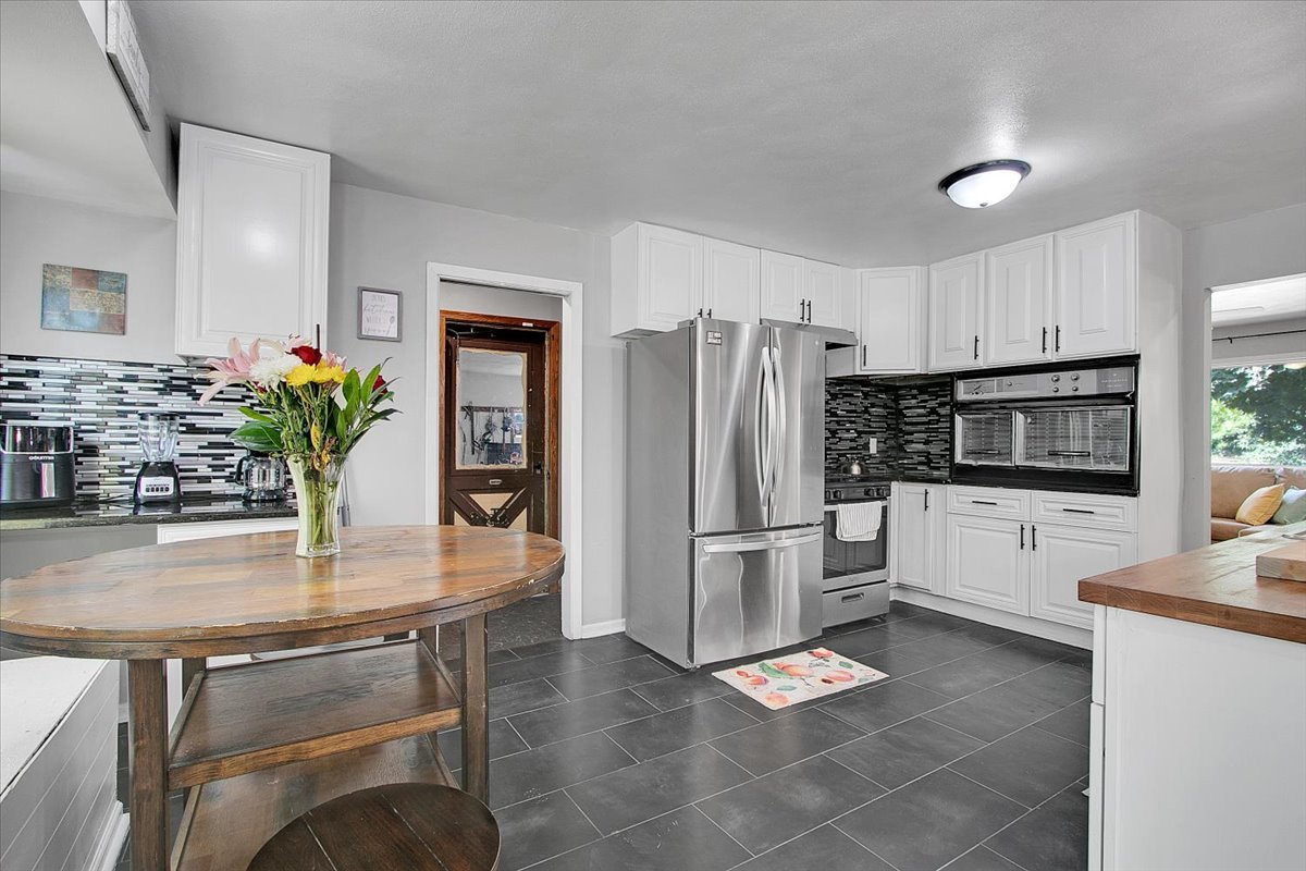 1708 Montague Road Rockford, IL 61102 - Photo 12 of 39 a kitchen with stainless steel appliances kitchen island granite countertop a refrigerator and a stove top oven