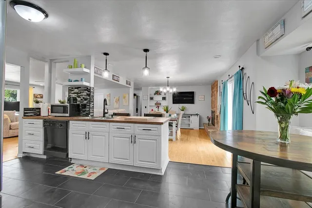 a kitchen with stainless steel appliances granite countertop a refrigerator dining table and chairs