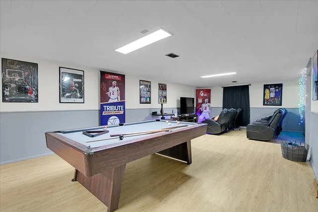 a living room with furniture a rug and paintings on the wall