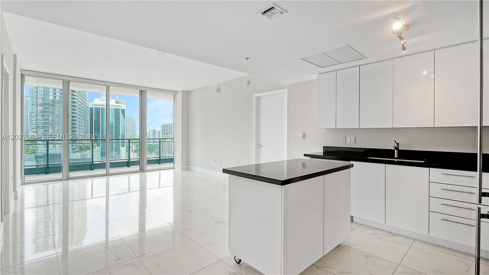 92 Southwest 3rd Street, Unit 1803 Miami, FL 33130 - Photo 4 of 29 a kitchen with granite countertop white cabinets and white appliances