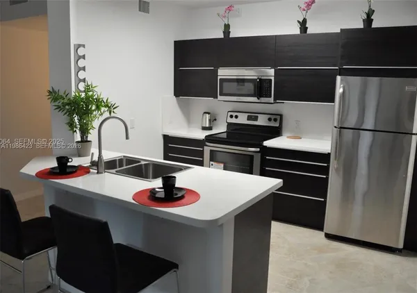 a kitchen with appliances a sink and cabinets