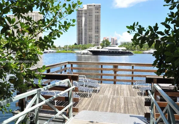 a roof deck with table and chairs and potted plants
