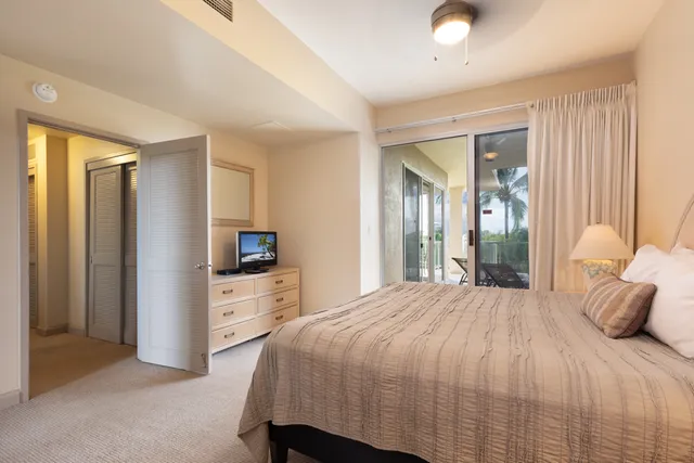 a bedroom with a bed and a lamp on dresser