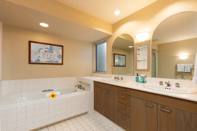 a bathroom with a tub a sink and mirror