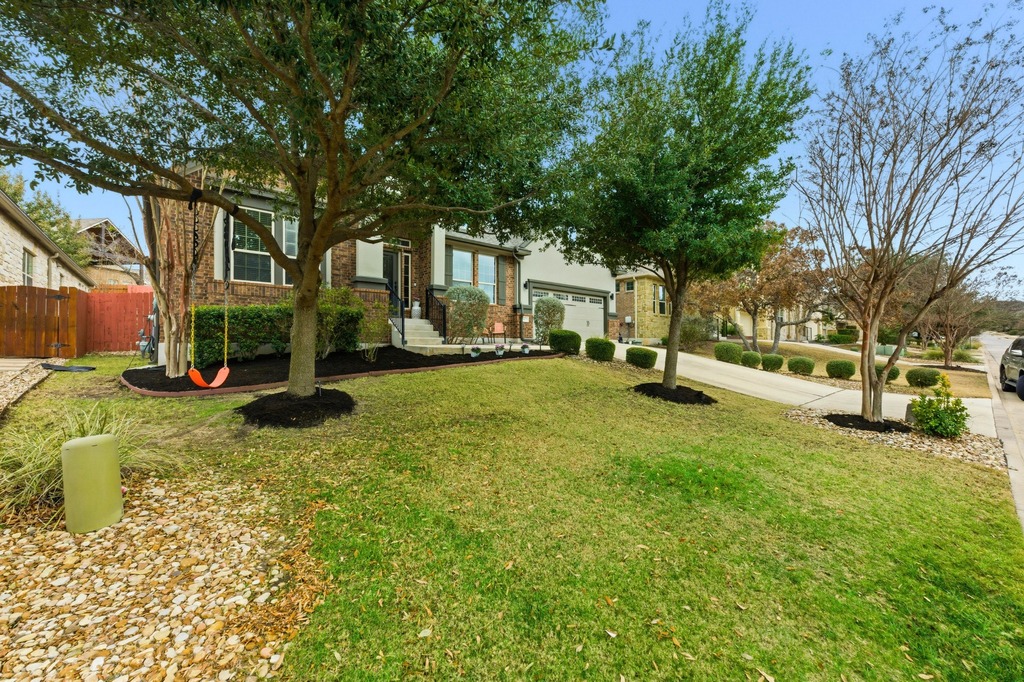 5425 Cherokee Draw Road Austin, TX 78738 - Photo 2 of 40 A well-maintained lawn and mature trees frame the appealing façade of this residence.