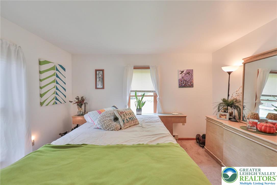 4608 Pine Ridge Drive West Bushkill, PA 18324 - Photo 38 of 62 A naturally illuminated bedroom offers a calm retreat with soft carpeting underfoot.