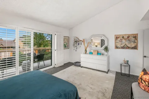 a spacious bedroom with a bed and wooden floor