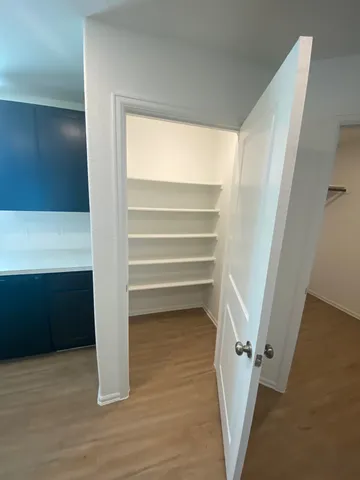 a view of walk in closet with empty racks