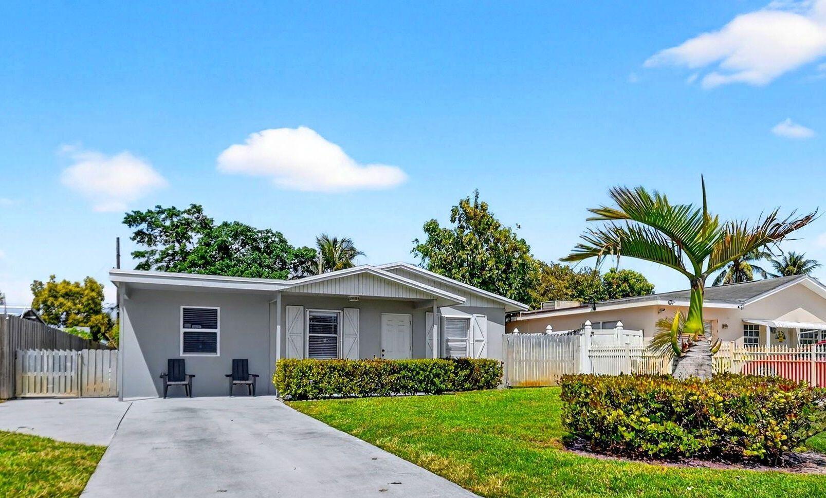 a front view of a house with a garden and plants