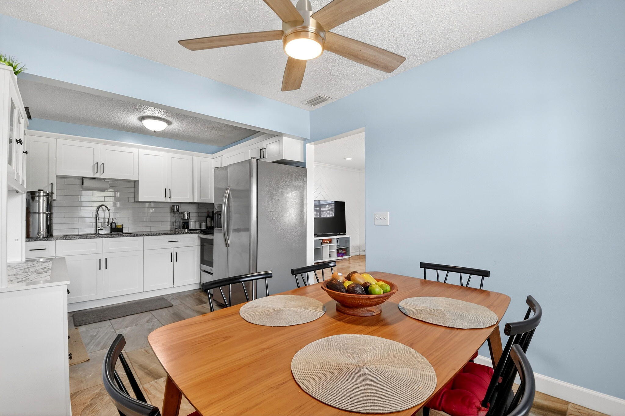 5721 Coconut Road West Palm Beach, FL 33413 - Photo 14 of 41 a kitchen with stainless steel appliances kitchen island granite countertop a dining table and chairs