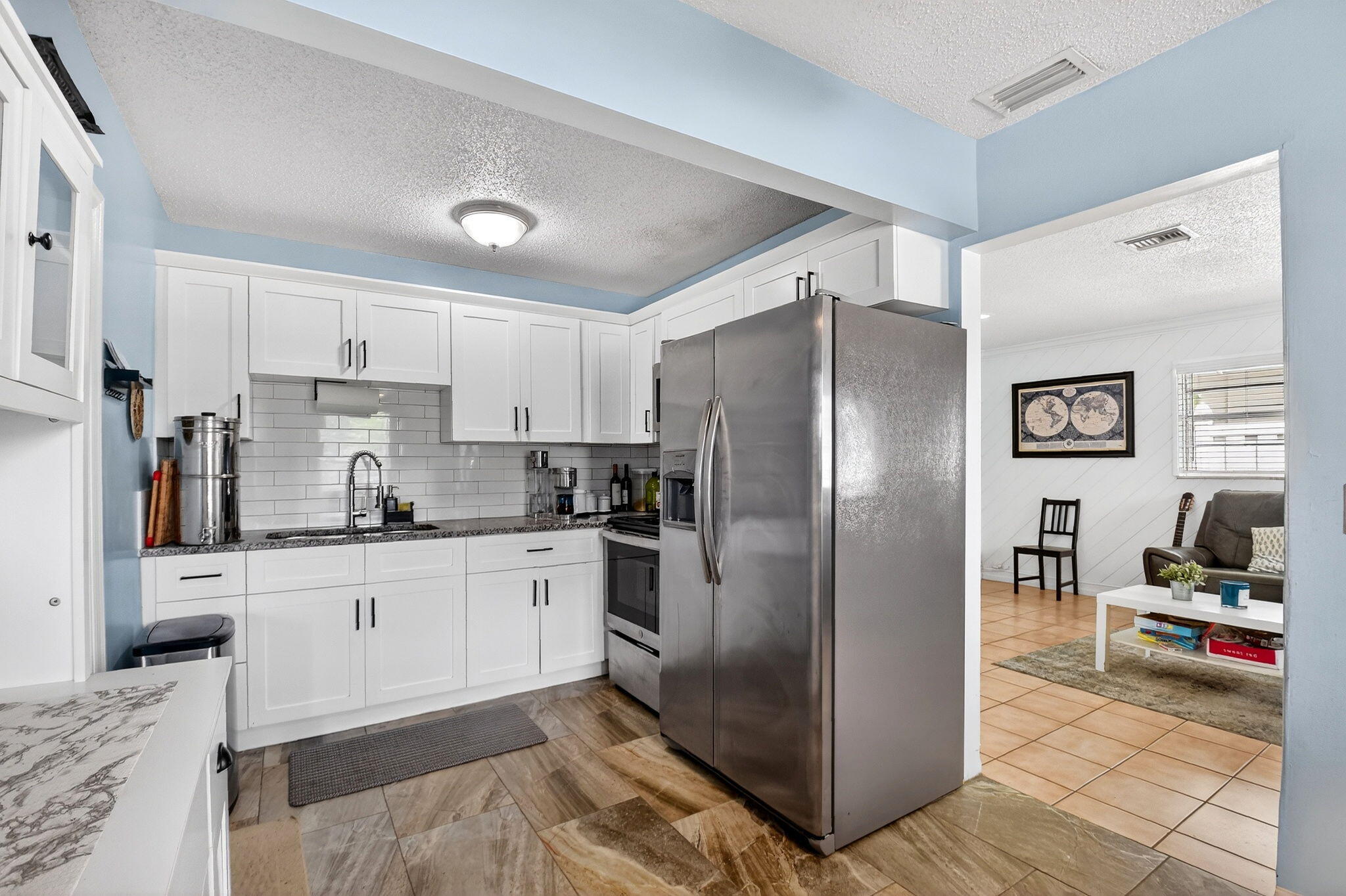 5721 Coconut Road West Palm Beach, FL 33413 - Photo 2 of 41 a kitchen with granite countertop a refrigerator and a stove top oven