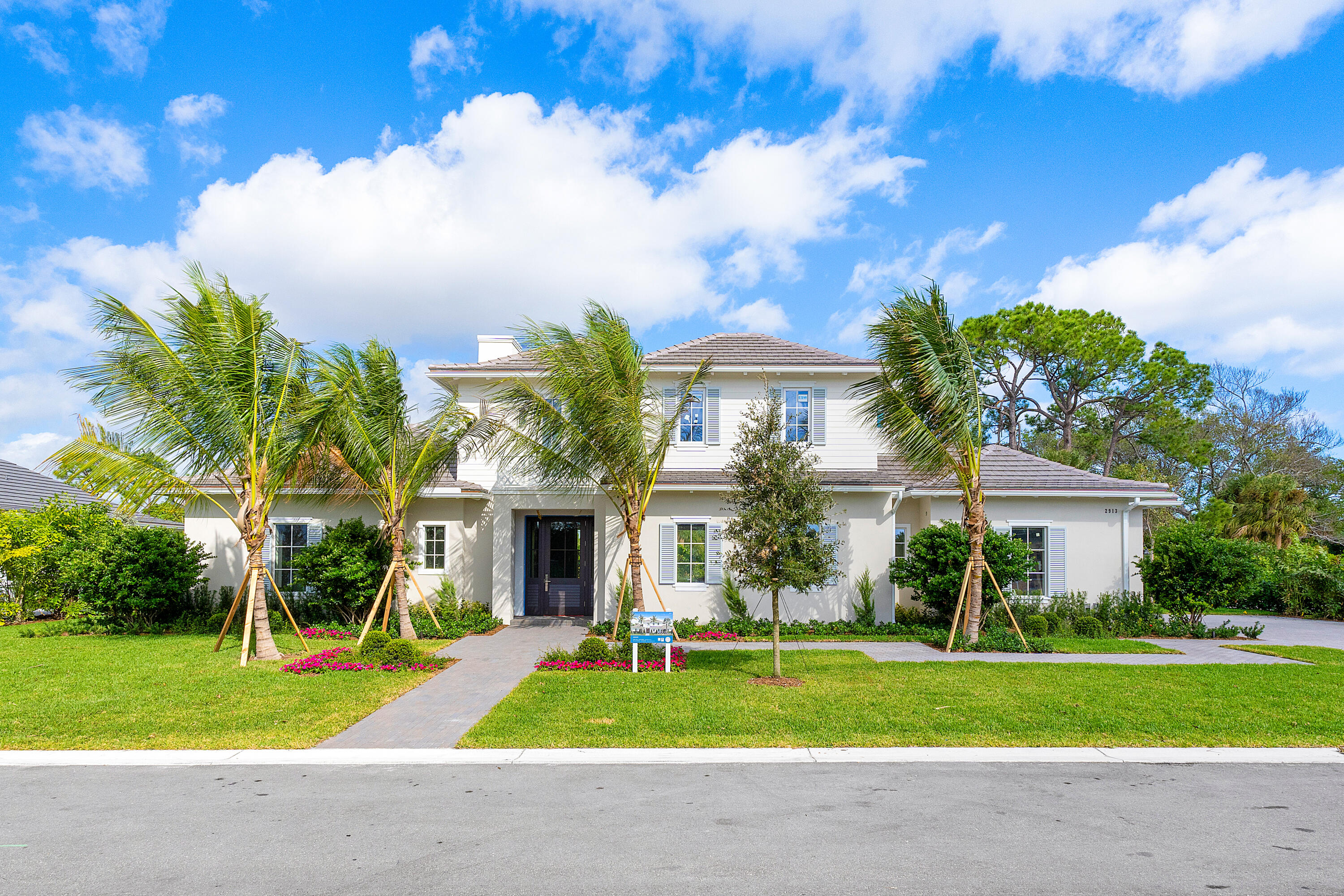 2913 Bluewater Cove Gulf Stream, FL 33483 - Photo 1 of 43 a front view of a house with a yard and garage