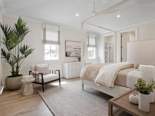 a spacious bedroom with a large bed and a potted plant