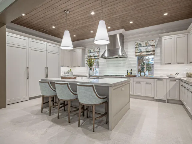 a kitchen with kitchen island granite countertop a sink and white cabinets
