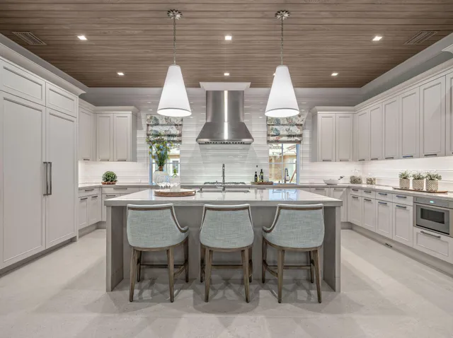 a kitchen with a white cabinets and chairs