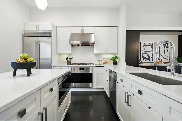 a kitchen with white cabinets and appliances