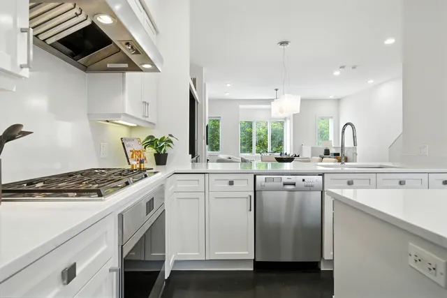 a kitchen with white cabinets and appliances