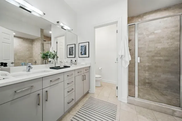 a spacious bathroom with a double vanity sink toilet and shower