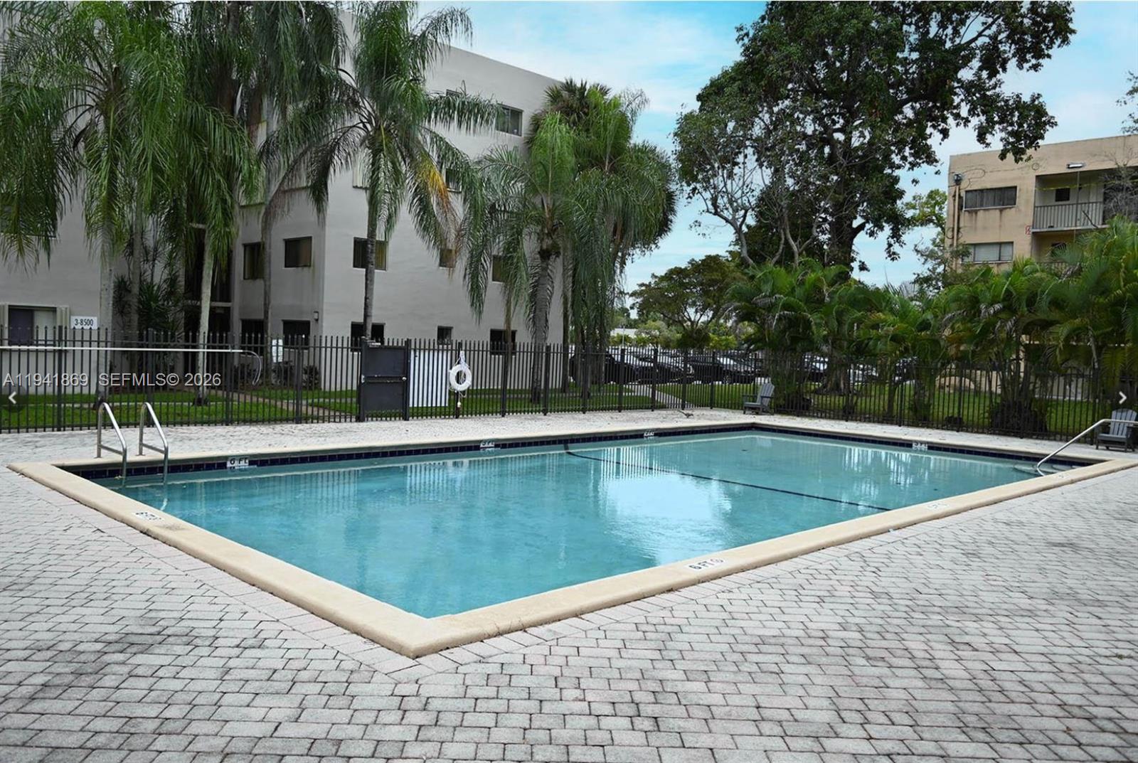 8400 Southwest 133rd Avenue Road, Unit 311 Miami, FL 33183 - Photo 1 of 11 a view of swimming pool with a table and chairs