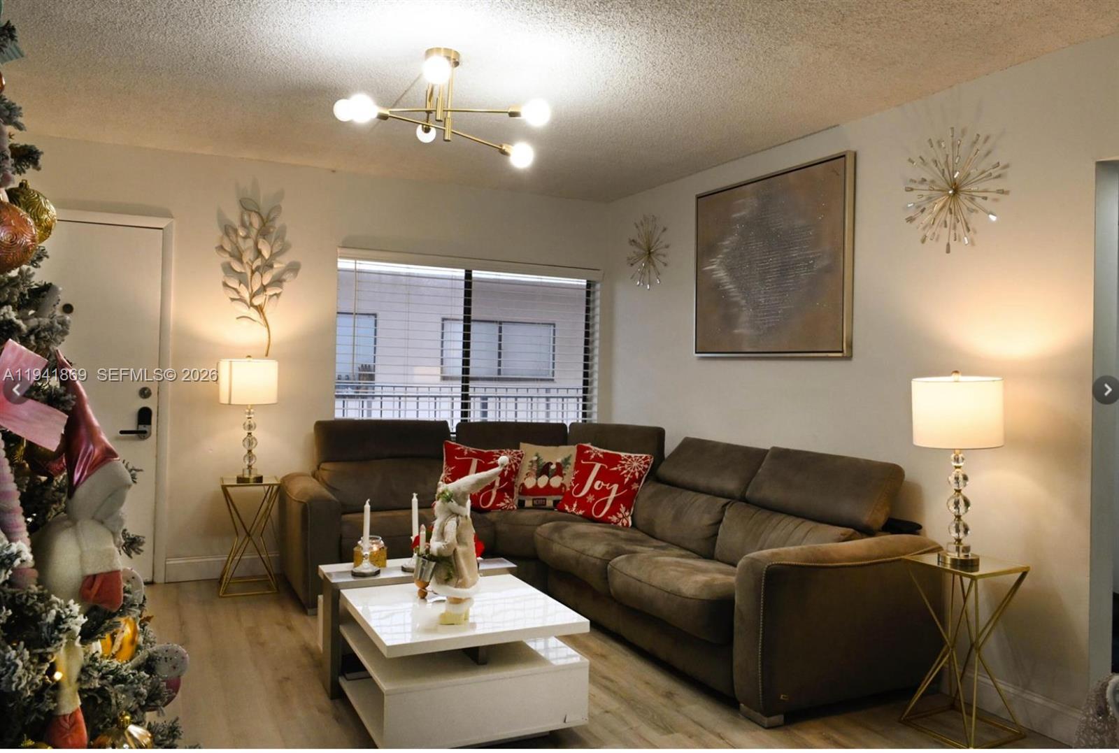 8400 Southwest 133rd Avenue Road, Unit 311 Miami, FL 33183 - Photo 6 of 11 a living room with furniture and a chandelier