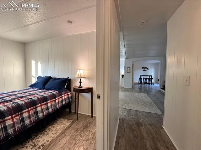 a view of a bedroom with a bed and wooden floor