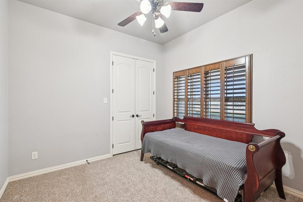 101 Maral Lane Azle, TX 76020 - Photo 18 of 36 a bedroom with a bed and a chandelier