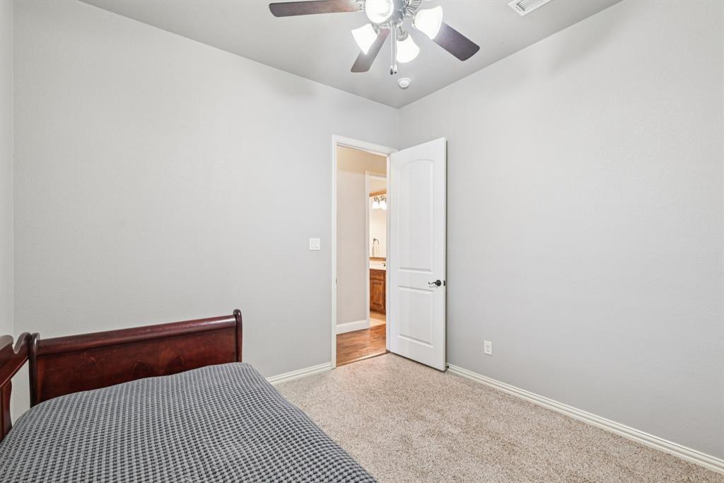 101 Maral Lane Azle, TX 76020 - Photo 19 of 36 a bedroom with a large bed and a chandelier