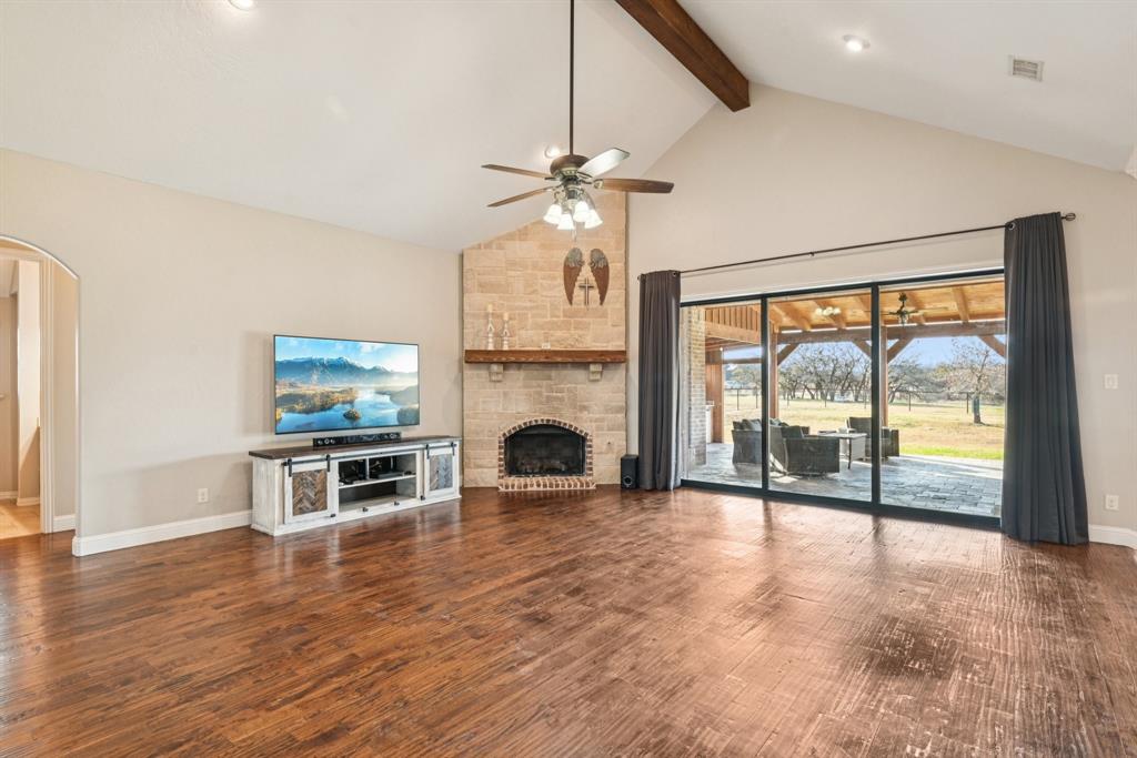 101 Maral Lane Azle, TX 76020 - Photo 5 of 36 a view of a livingroom with a fireplace a ceiling fan and wooden floor