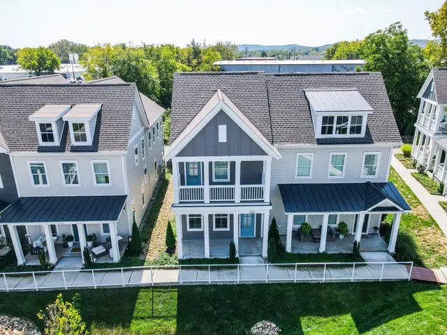 a dining room with wooden floor a chandelier a wooden table and chairs