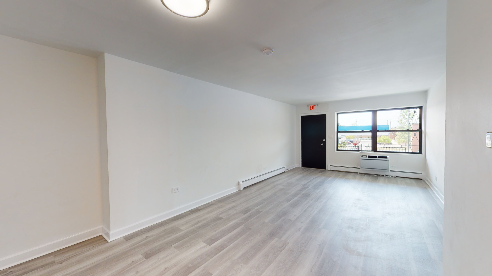 8100 Oakton Street, Unit 203 Niles, IL 60714 - Photo 7 of 15 an empty room with wooden floor and windows