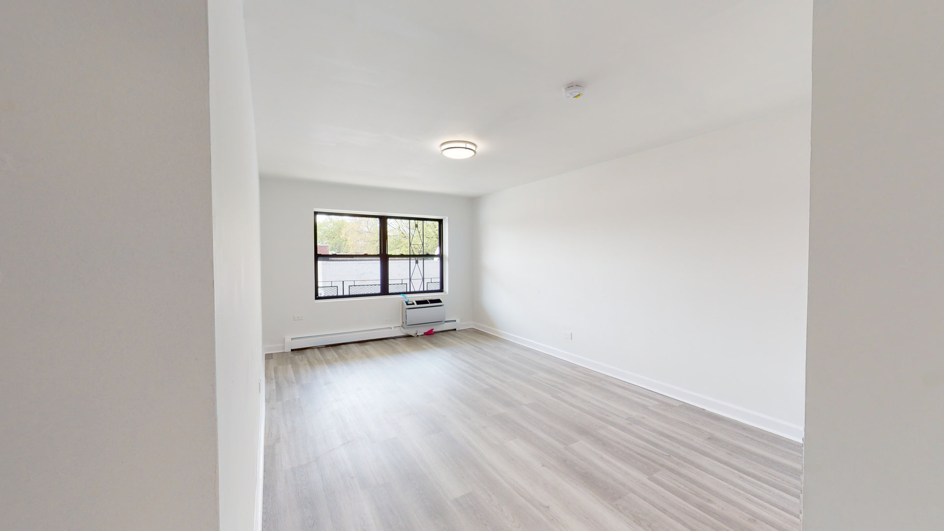 8100 Oakton Street, Unit 203 Niles, IL 60714 - Photo 8 of 15 a view of an empty room with wooden floor and a window
