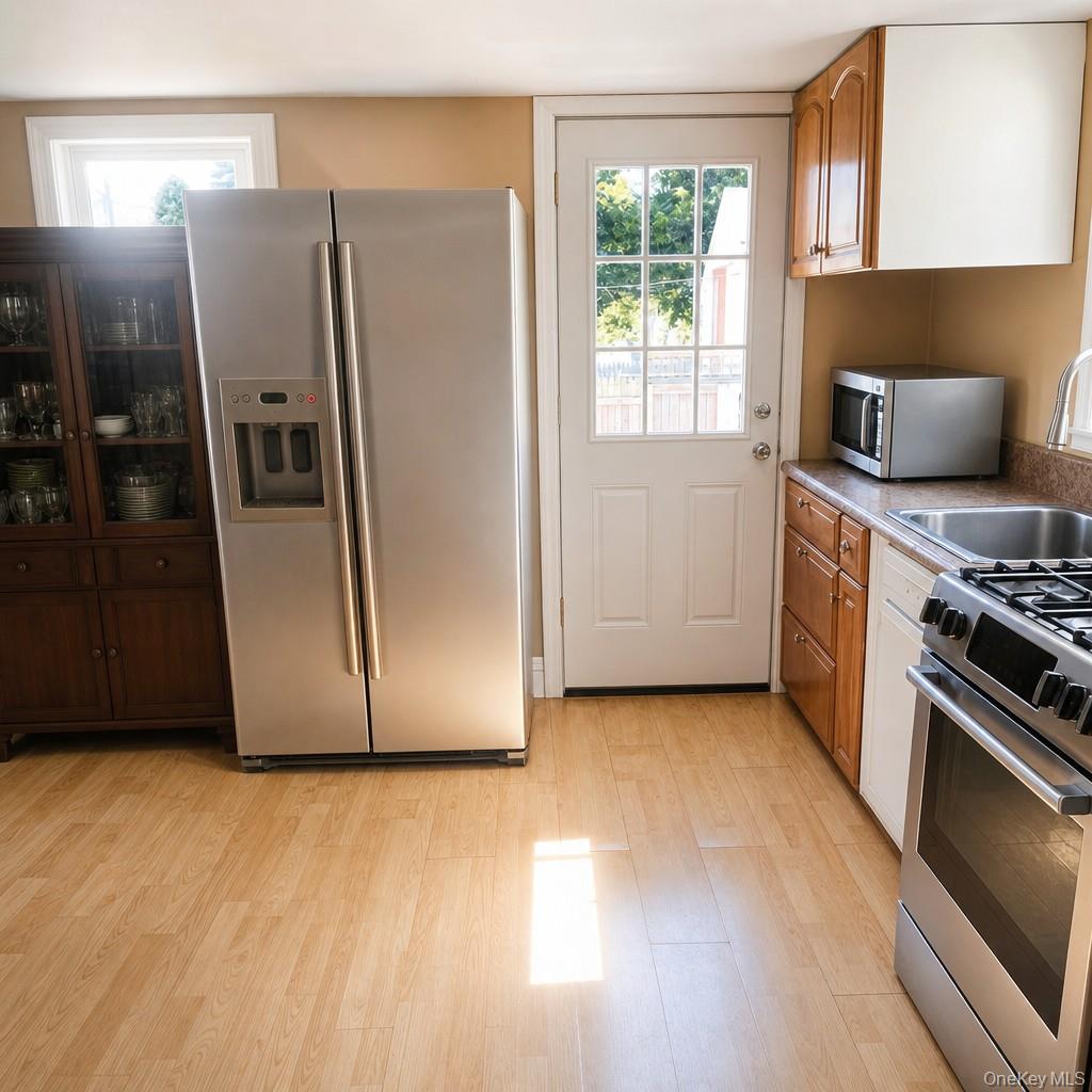 719 North Sea Road Southampton, NY 11968 - Photo 3 of 6 a kitchen with stainless steel appliances a refrigerator a stove a sink and a window