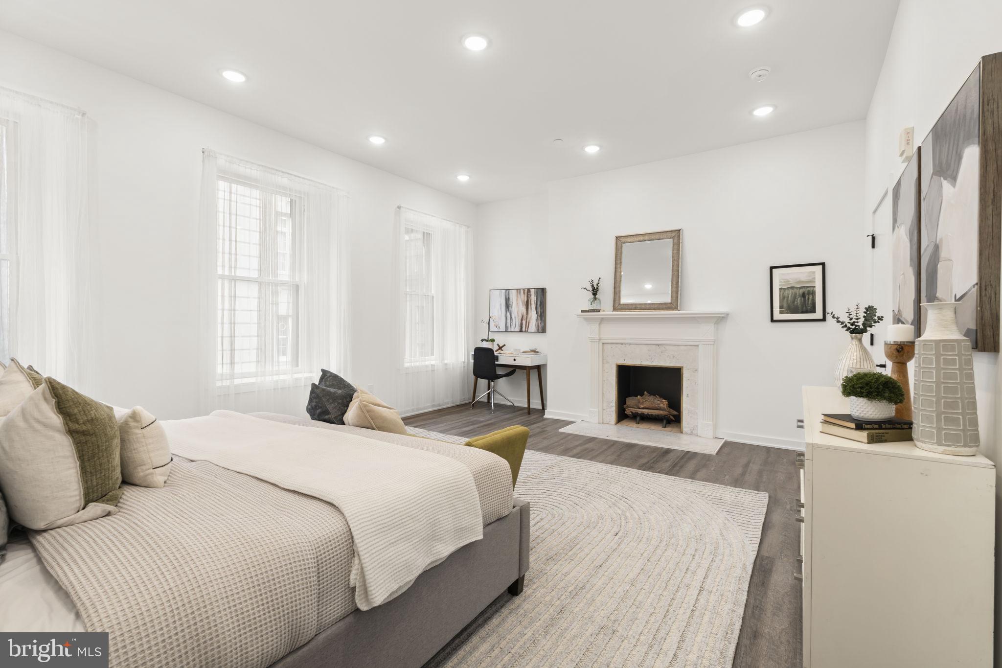 1602-4 Locust Street, Unit 202 Philadelphia, PA 19103 - Photo 11 of 25 a bedroom with a bed and a fireplace