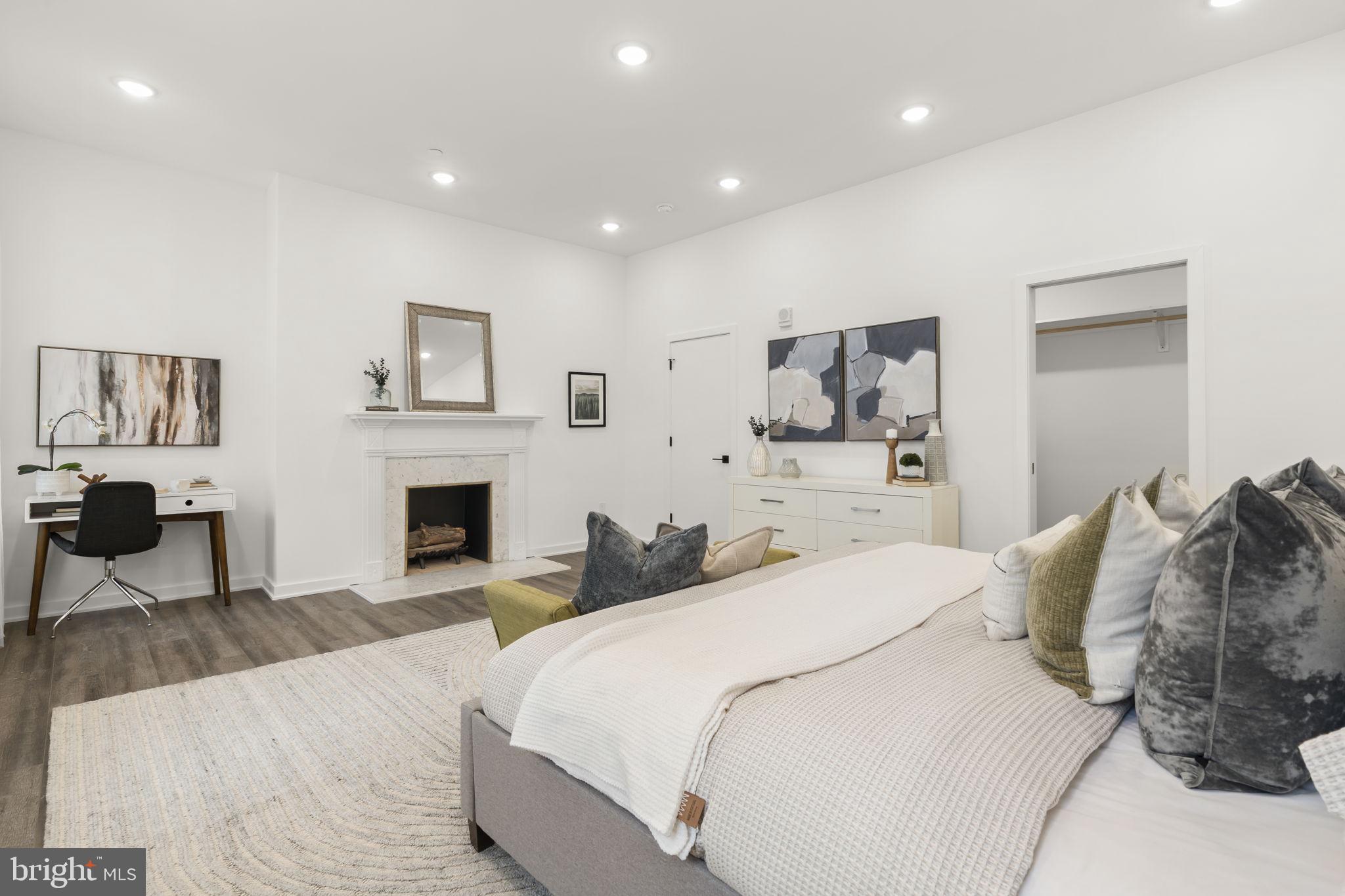 1602-4 Locust Street, Unit 202 Philadelphia, PA 19103 - Photo 13 of 25 a spacious bedroom with a bed and a fireplace