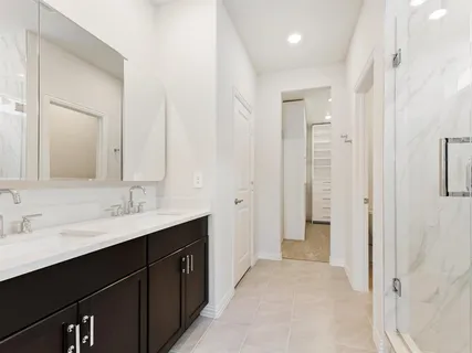 a bathroom with a double vanity sink mirror and shower