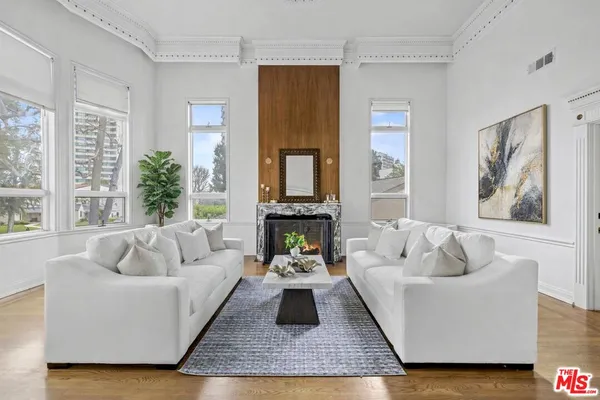a living room with furniture fireplace and a large window
