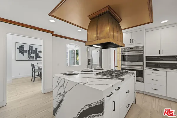 a kitchen that has a stove a table and chairs in it