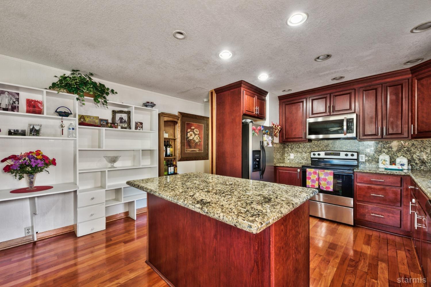 a kitchen with granite countertop cabinets and wooden floor