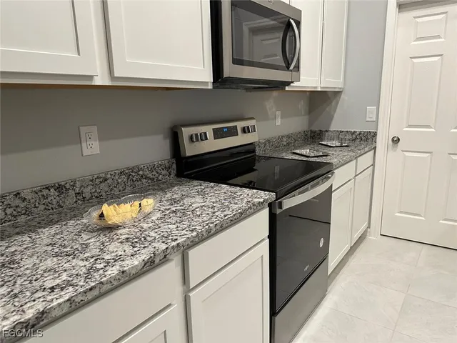 a kitchen with stainless steel appliances granite countertop a refrigerator and a stove