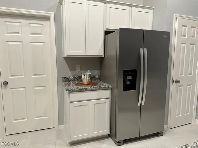 a bathroom with a granite countertop bathtub sink vanity mirror and toilet