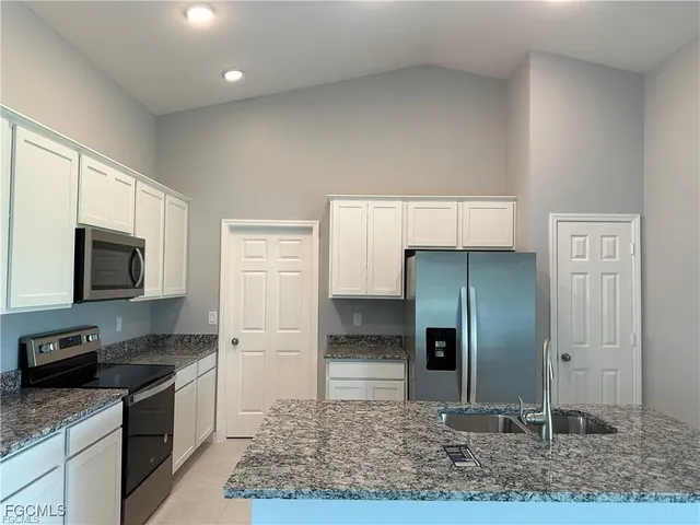 a kitchen with stainless steel appliances granite countertop a refrigerator and a sink